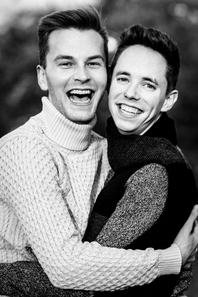 man embrace while smiling at the camera
