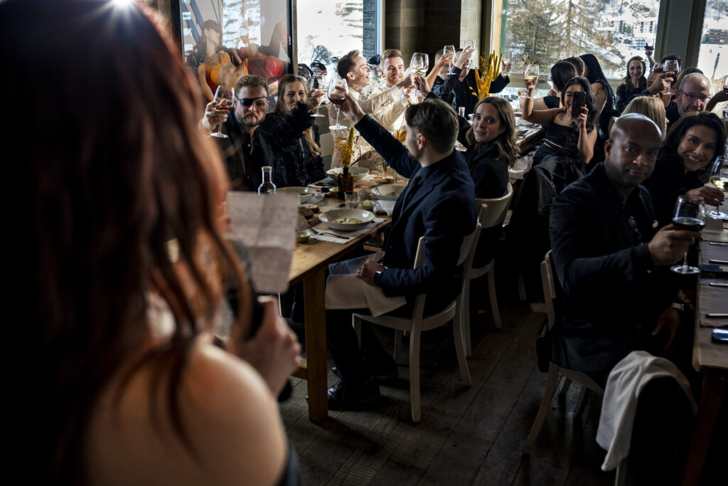 Matt and Brady's wedding guests raising their glasses in a heartfelt toast at their Swiss Alps wedding reception at Cervo Resort in Zermatt, Switzerland