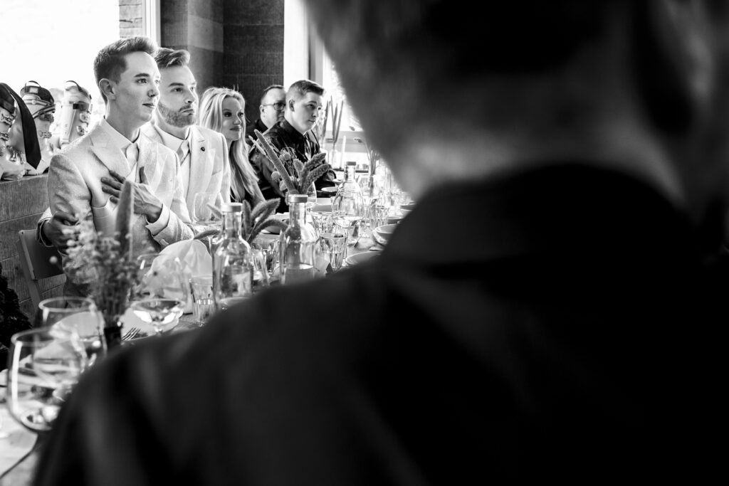 Matt and Brady's wedding guests raising their glasses in a heartfelt toast at their Swiss Alps wedding reception at Cervo Resort in Zermatt, Switzerland