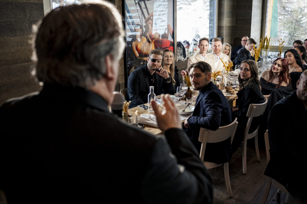 Matt and Brady's wedding guests raising their glasses in a heartfelt toast at their Swiss Alps wedding reception at Cervo Resort in Zermatt, Switzerland