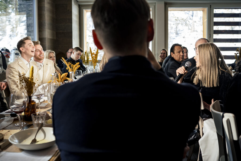 Matt and Brady's wedding guests raising their glasses in a heartfelt toast at their Swiss Alps wedding reception at Cervo Resort in Zermatt, Switzerland