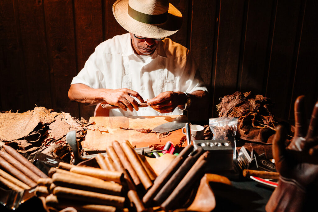 Cigar Roller During Wedding Reception at Avalon Legacy Ranch in Mckinney by DFW Wedding Photographers The MacMeekens