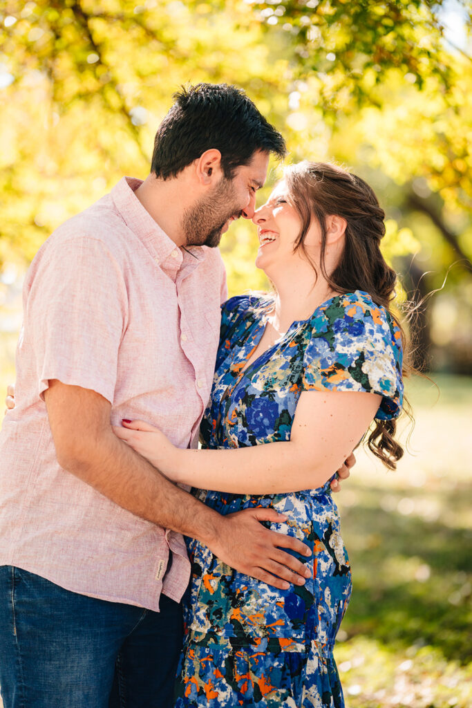 Couple embracing on a sunlit trail during their Dallas engagement session at Reverchon Park.
