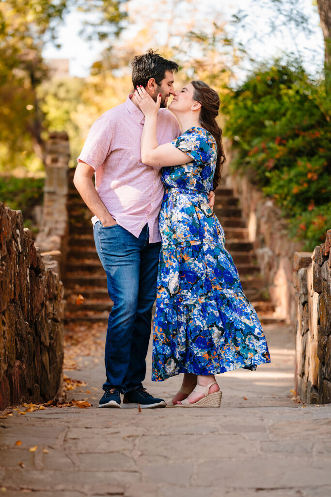 Laughing moment between couple beneath golden leaves at Reverchon Park.