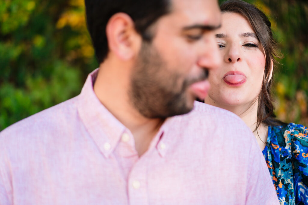 Laughing moment between couple beneath golden leaves at Reverchon Park.