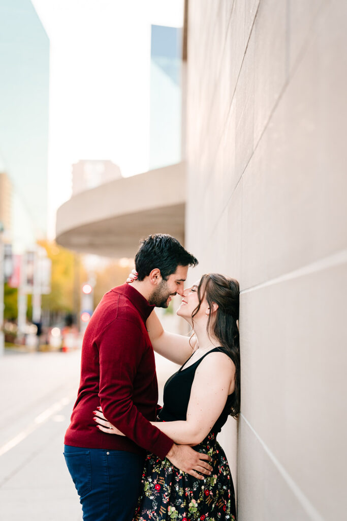 Romantic photo of couple leaning against a modern wall at the Meyerson in Downtown Dallas.