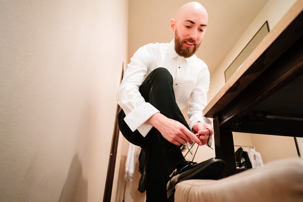 Candid groom getting ready moments before Dallas wedding ceremony at Tyler Street Church