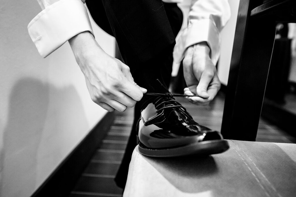 Candid groom getting ready at The Carlisle Room moments before Dallas wedding ceremony at Tyler Street Church