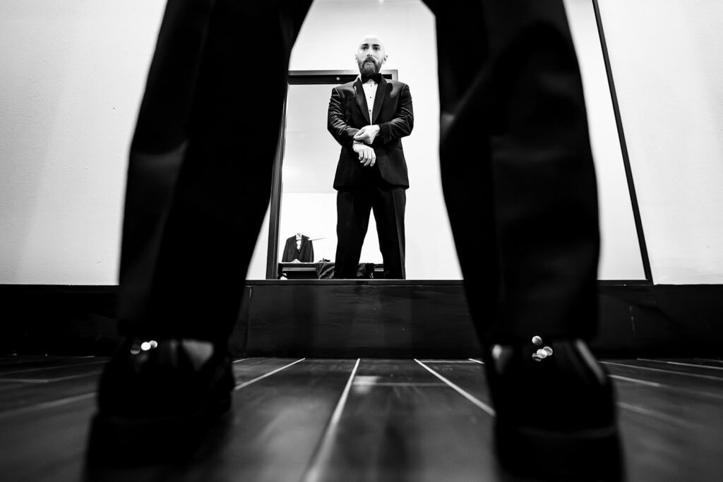 Candid groom getting ready at The Carlisle Room moments before Dallas wedding ceremony at Tyler Street Church