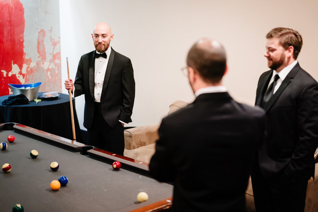 Candid groom getting ready at The Carlisle Room moments before Dallas wedding ceremony at Tyler Street Church