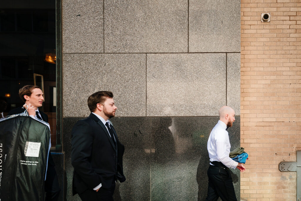 Candid groom getting ready at The Carlisle Room moments before Dallas wedding ceremony at Tyler Street Church