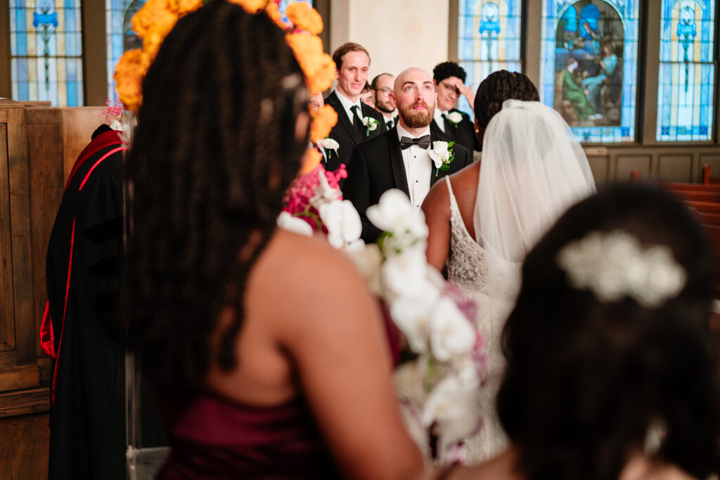 Bride and groom standing beneath stained glass windows at Tyler Street Church wedding