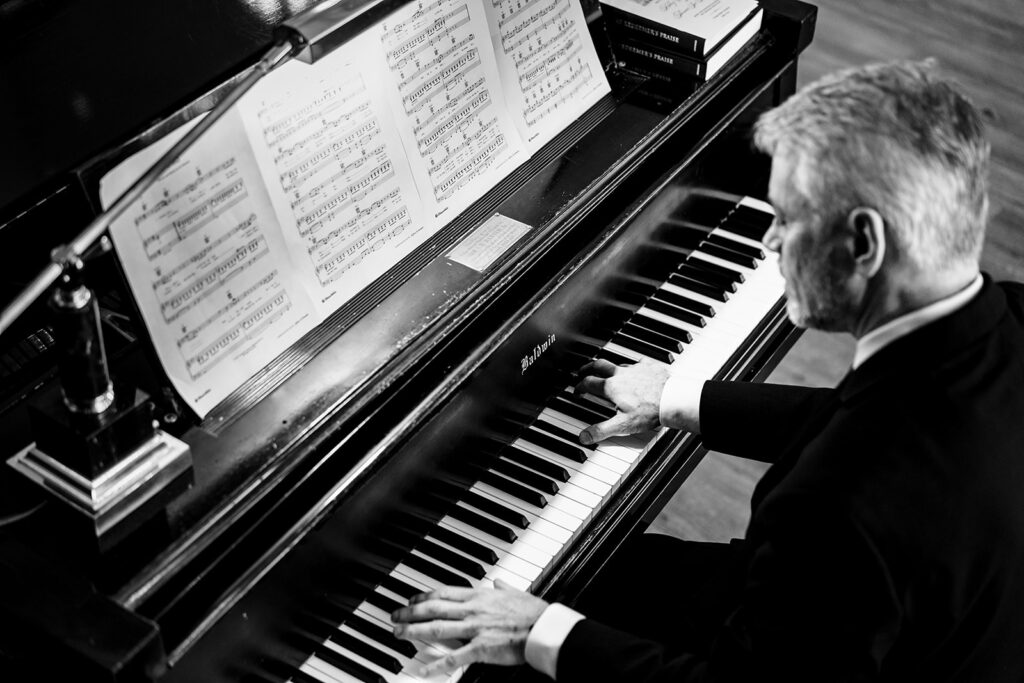 Musician plays piano during wedding ceremony at Tyler Street Church in Dallas