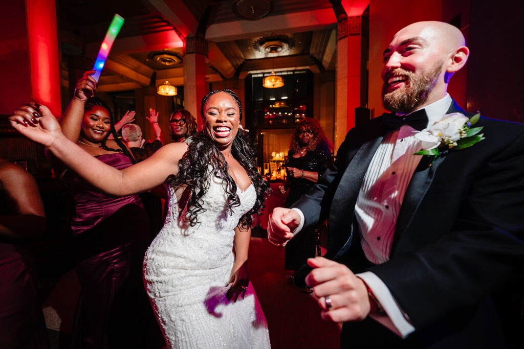 Bride and groom celebrating wedding reception with guests on the dance floor in Dallas at The Carlisle Room