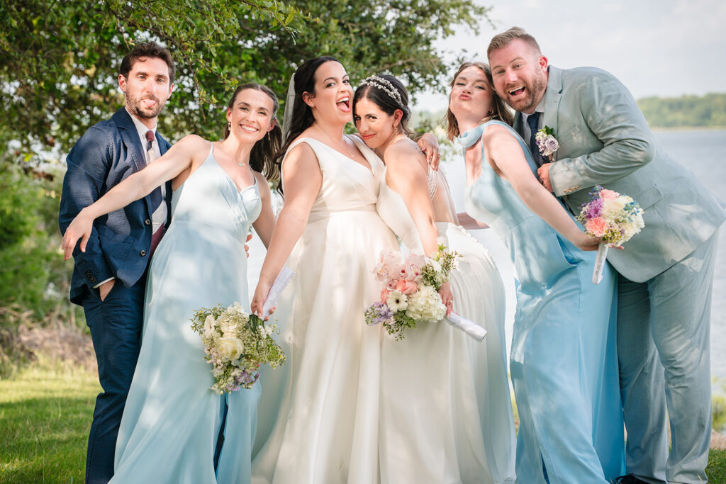 Brides with their wedding party During North Texas LGBTQ Wedding Portraits at The Filter Building on White Rock Lake by Dallas Inclusive Wedding Photographers