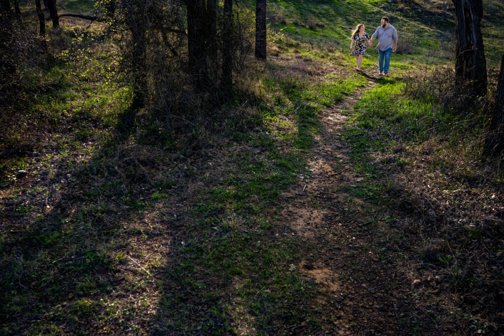 man and woman walk along hiking trail together