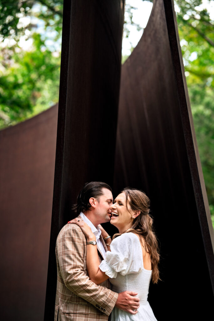 man and woman embrace near art sculpture