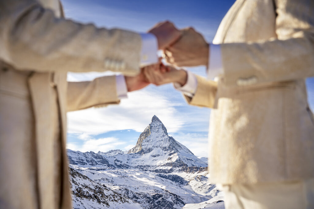 Matt & Brady in custom Don Morphy suits posing for LGBTQ wedding portraits at the Matterhorn in Zermatt, Switzerland with destination wedding photographers The MacMeekens