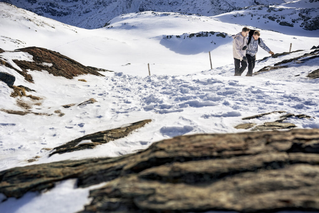 Matt & Brady laughing together in the snow during their adventurous LGBTQ wedding photography session in Zermatt, Switzerland