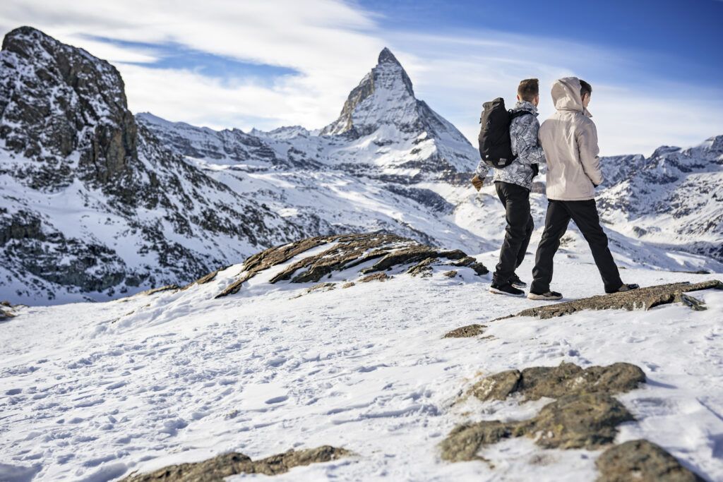 Matt & Brady laughing together in the snow during their adventurous LGBTQ wedding photography session in Zermatt, Switzerland