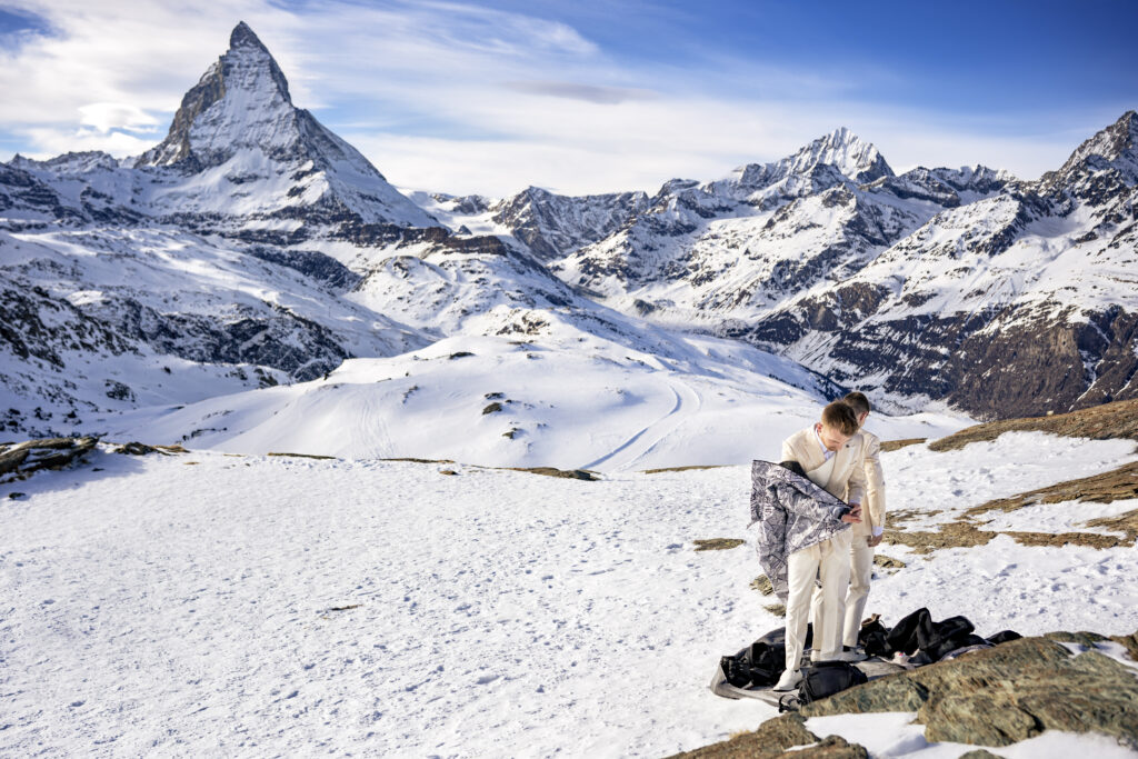 Matt & Brady changing into their custom Don Morphy suits in the snow during their adventurous LGBTQ wedding photography session in Zermatt, Switzerland