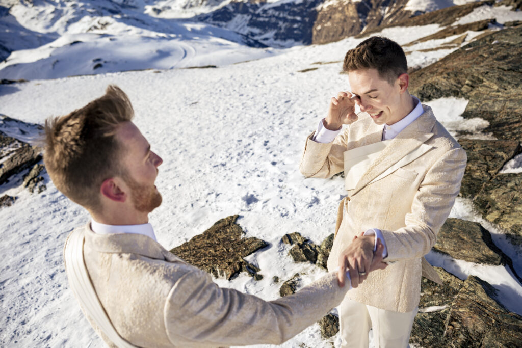 Matt & Brady in custom Don Morphy suits posing for LGBTQ wedding portraits at the Matterhorn in Zermatt, Switzerland with destination wedding photographers The MacMeekens